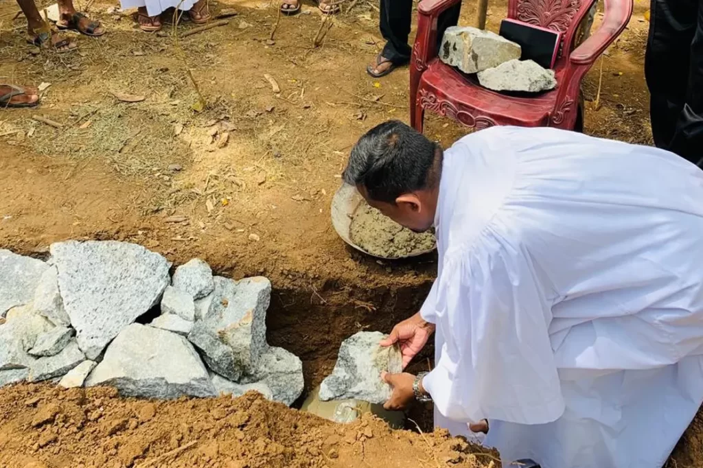 Priest placing a rock